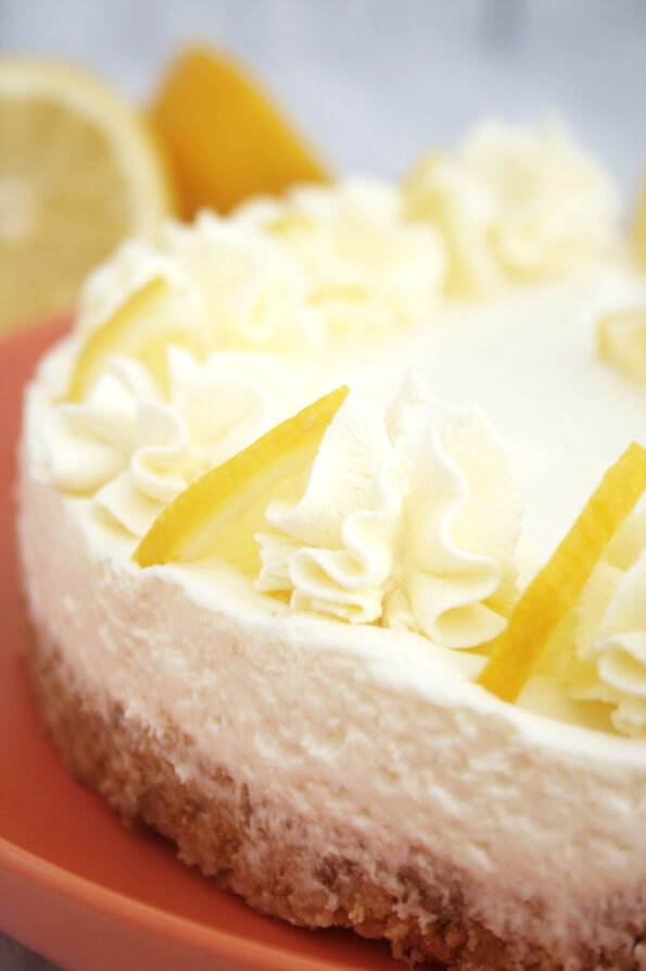 a no bake lemon cheesecake on a red serving plate.