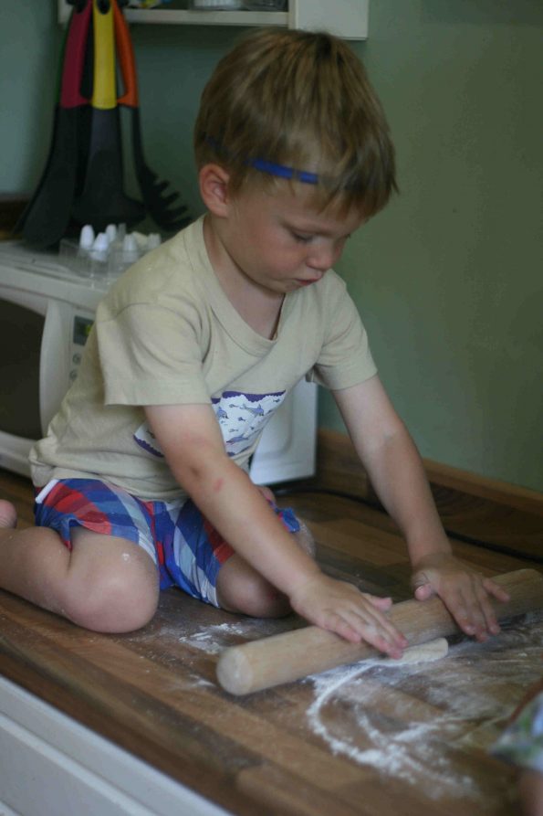 child rolling dough