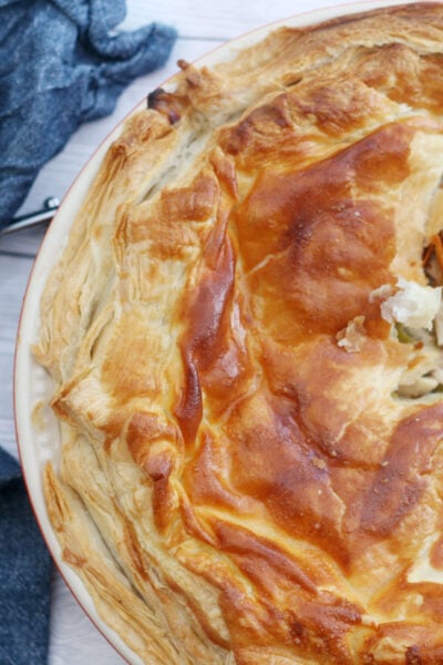 chicken leek and mushroom pie shown from the top with a slice removed