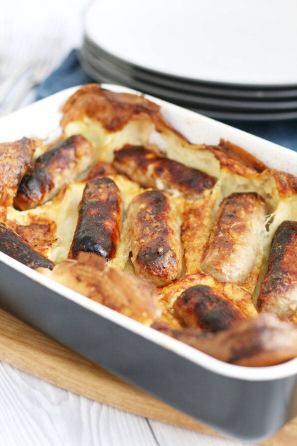 toad in the hole in a dish with plates in the background