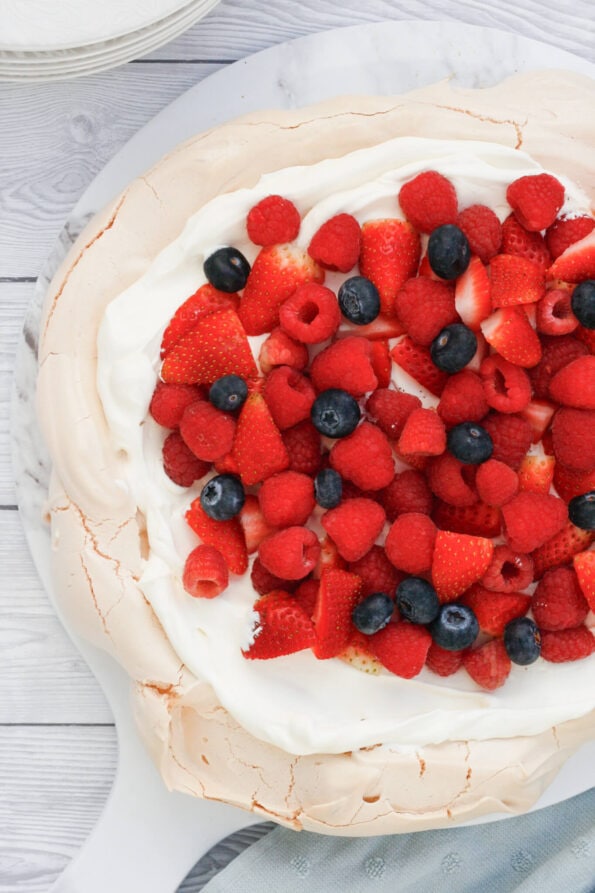 A summer berry pavlova on a serving plate. 