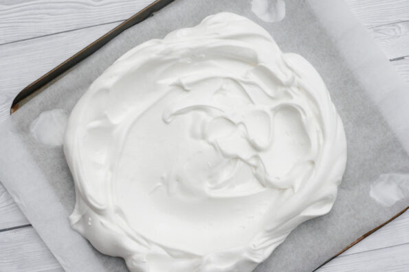 An unbaked pavlova on a baking tray.