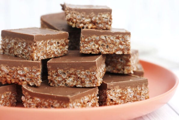 Mars bar sliced piled on a red plate.