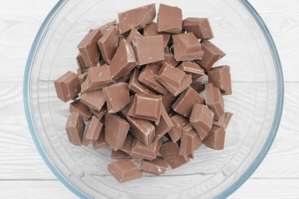 chocolate broken into pieces in a glass bowl.