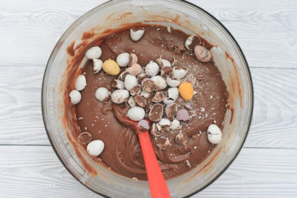 Mini Eggs added to a bowl of fudge.