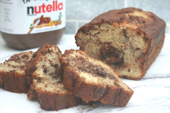 Banana and chocolate loaf sliced with a jar of nutella in the background