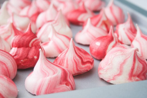 Meringue kisses on a baking tray.