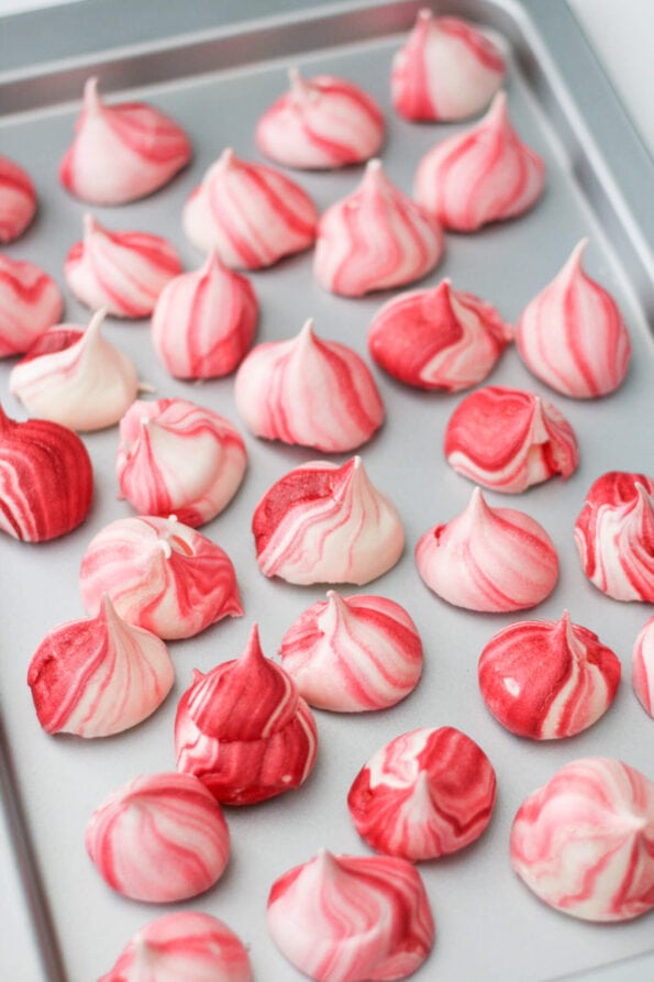 Meringue kisses on a baking tray.