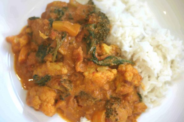 chicken curry with rice in a white dish