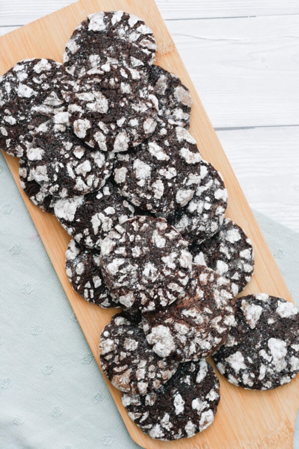 chocolate crinkle cookies on a wooden serving board.