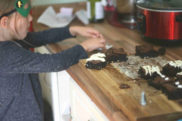 child decorating mummy brownies