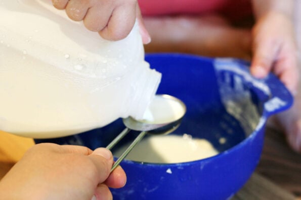 measuring milk with a tablespoon