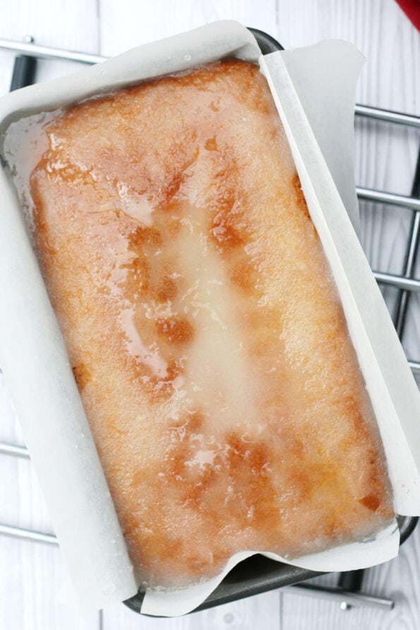 lemon drizzle cake in the baking tin with the drizzle just added