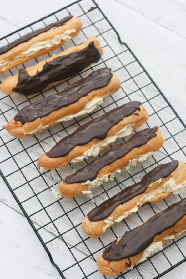 chocolate eclairs on a wire rack.