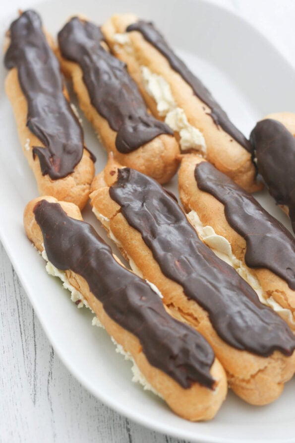 chocolate eclairs on a serving plate.