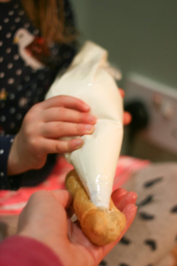 filling an eclair with cream.