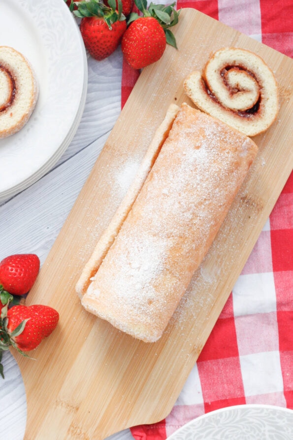Mary Berry's Swiss roll on a wooden serving plate. 