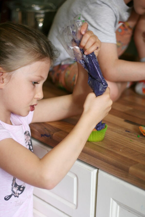 piping icing onto a monster cupcake