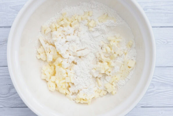 butter cut into pieces with flour in a bowl.