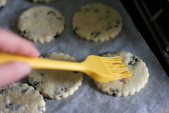 brushing egg white onto Shrewsbury biscuits