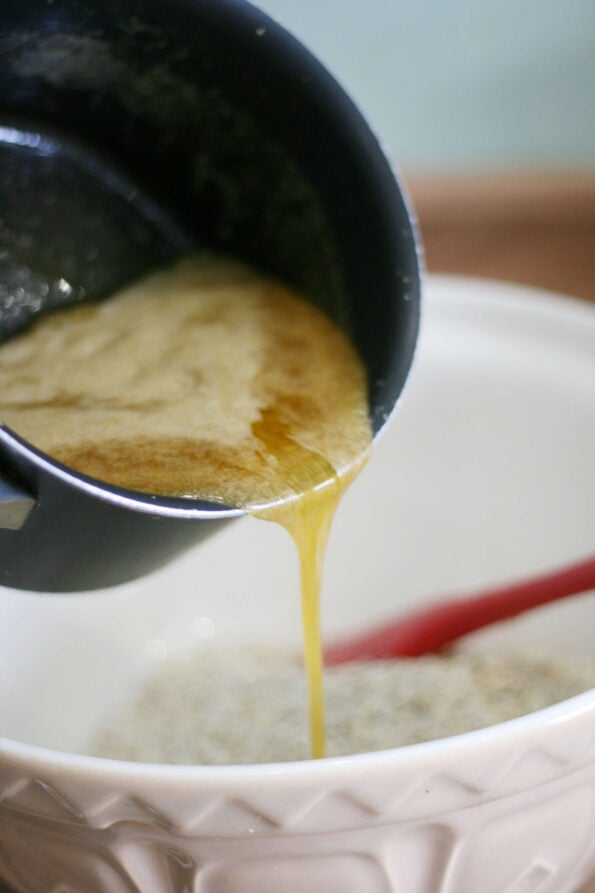 pouring melted butter into a mixing bowl