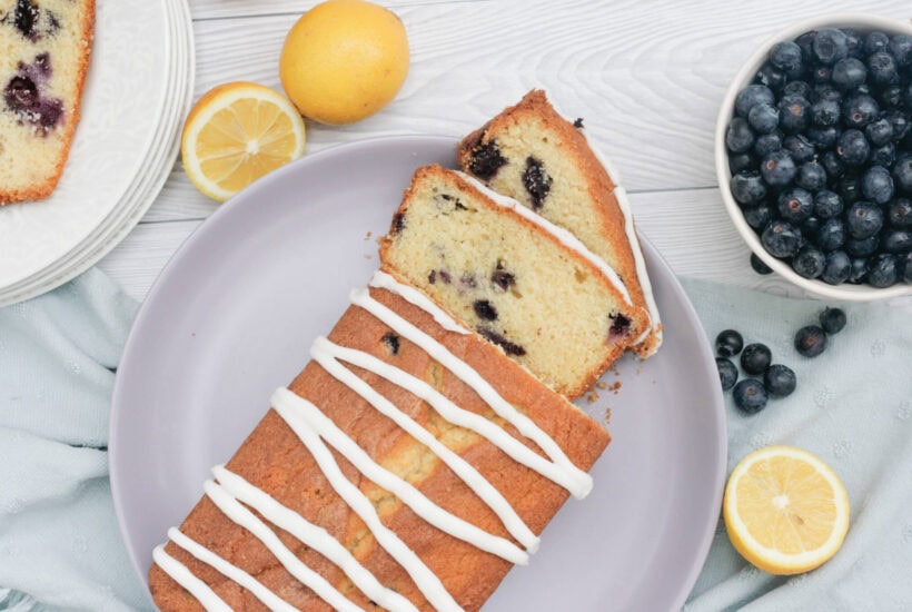 lemon and blueberry loaf cake on a purple plate.