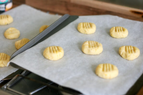 orange biscuits on a baking tray before going in the oven