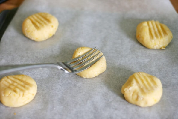 orange biscuits being pressed down with a fork