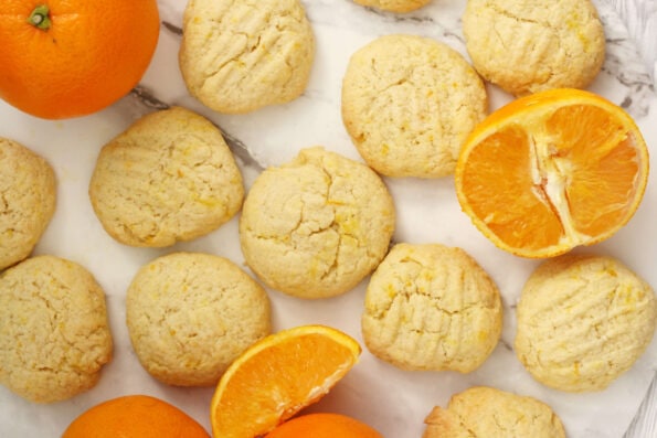 orange biscuits arranged on a serving plate with some orange segments