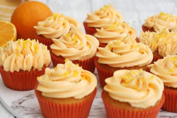 orange cupcakes with an orange in the background