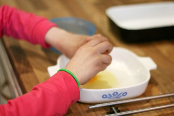child cracking an egg