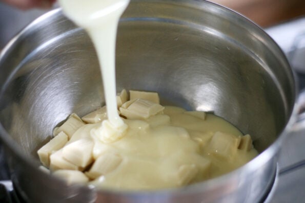 adding condensed milk to a bowl