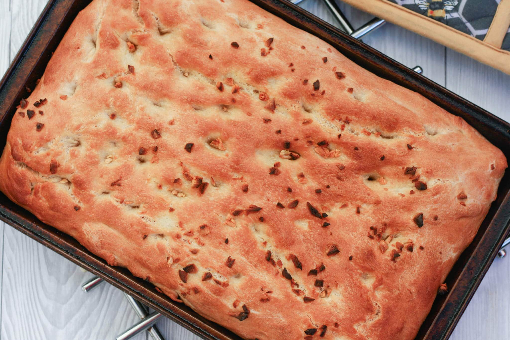 homemade garlic focaccia in a baking tray.