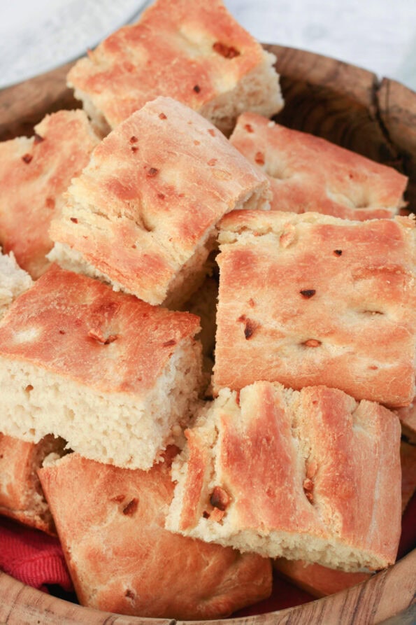 homemade garlic focaccia sliced in a wooden bowl.