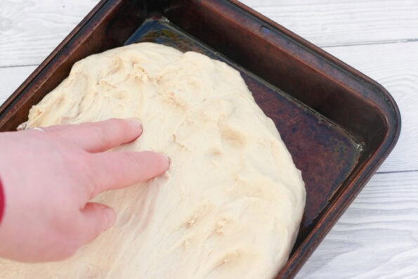 making focaccia in a baking tray.