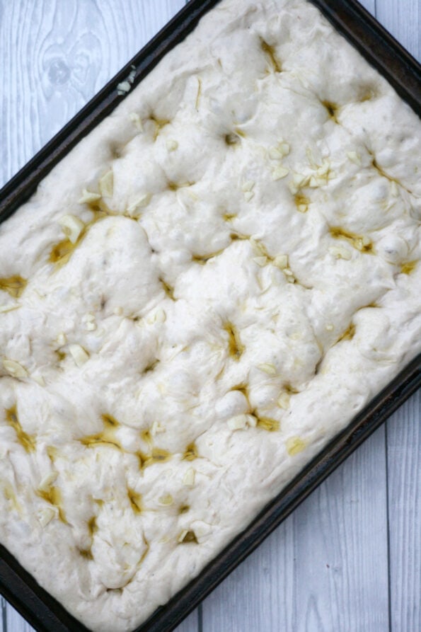 garlic focaccia in a baking tray before being baked.