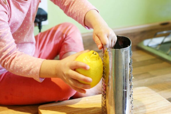 child zesting a lemon with a grater