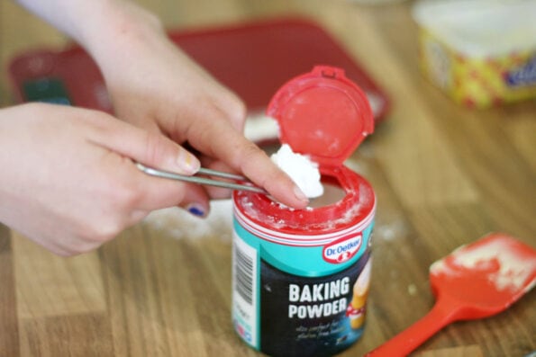 child measuring baking powder