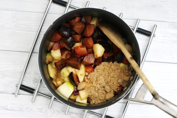 plums and apples in a pot with sugar
