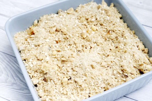 plum and apple crumble in a dish before being baked
