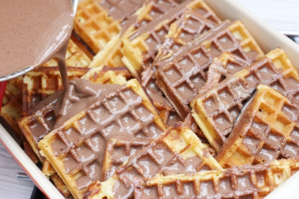 pouring chocolate custard on top of waffles.