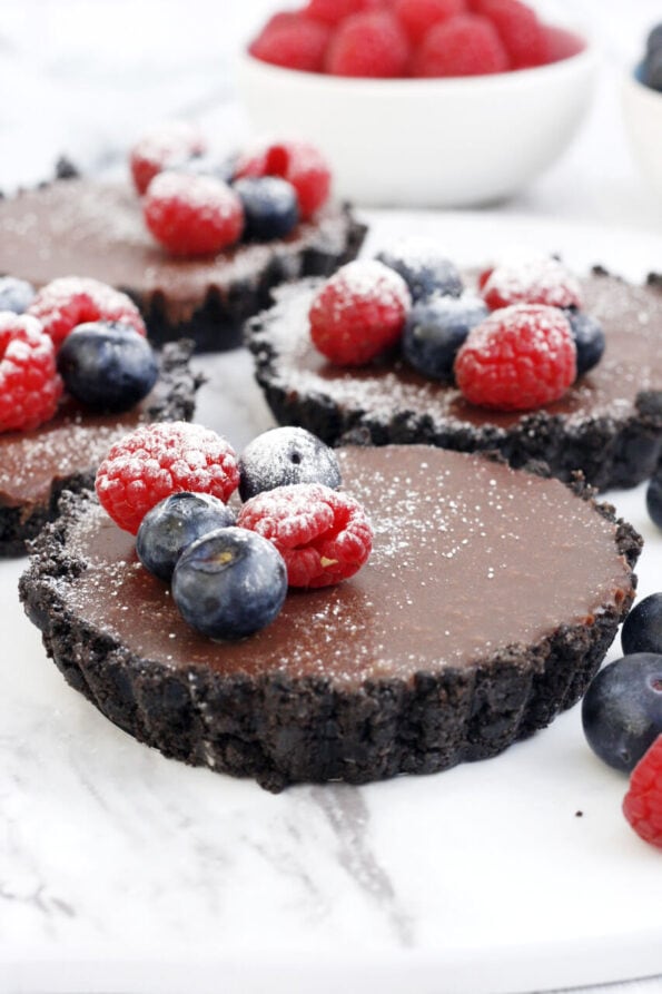 mini no bake chocolate tarts with berries on top