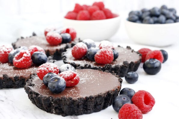 no bake chocolate tarts with berries on top.