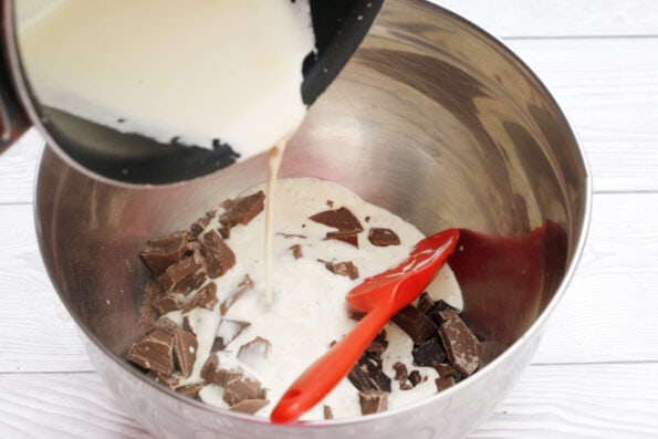 pouring hot cream over chocolate in a bowl.