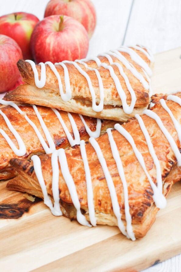 Apple turnovers on a wooden serving board.