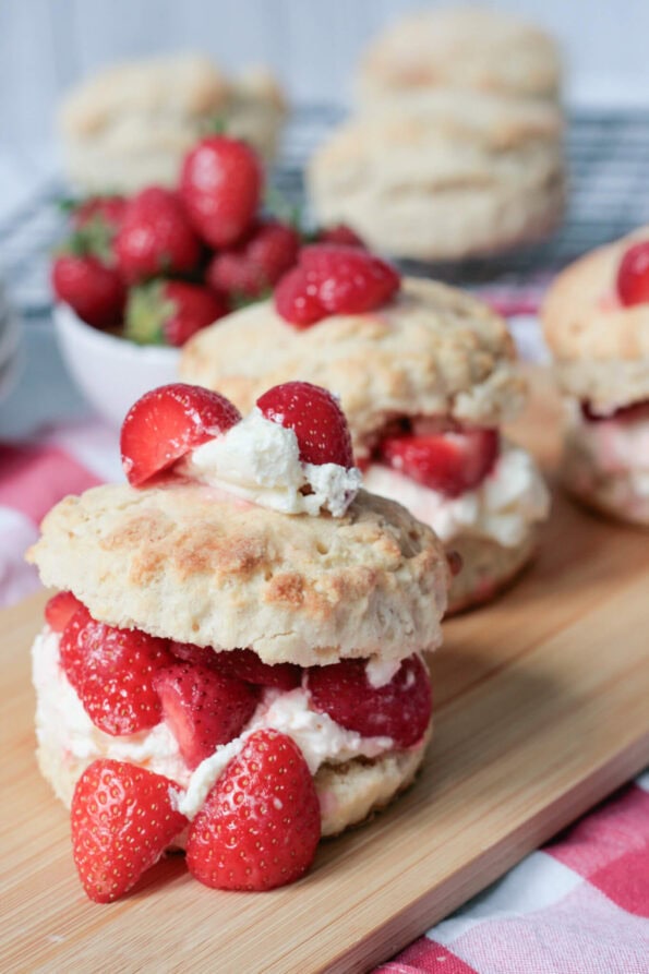 strawberry shortcakes on a wooden serving board.