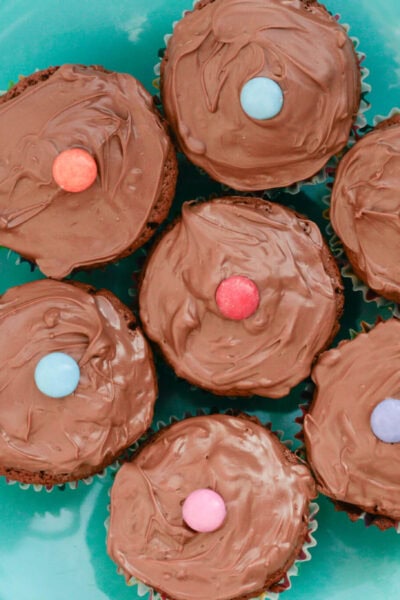 Smarties cupcakes on a blue plate.
