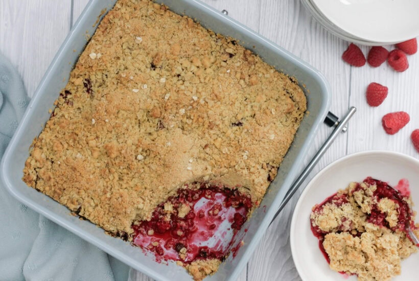 raspberry crumble in a light blue baking dish.