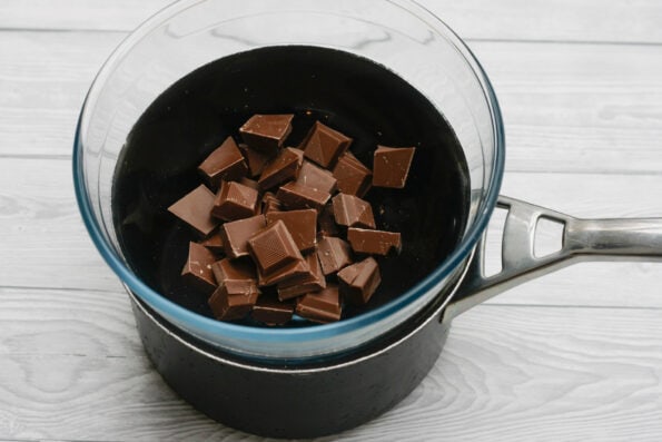 pieces of chocolate in a bowl over a pan of water.