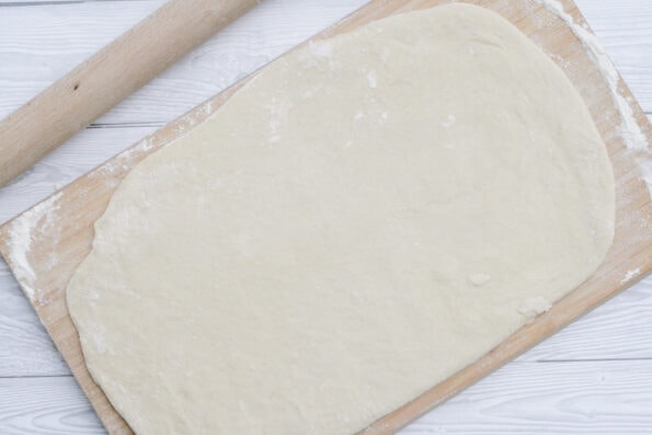 dough rolled out onto a wooden board.